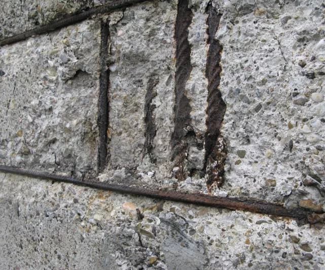 Freigelegte korrodierte Armierungseisen in abgeplatztem Sichtbeton
